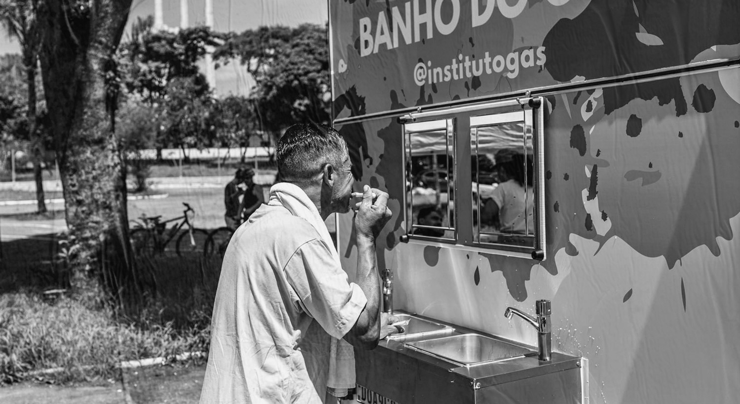 Foto de pessoa escovando os dentes em trailer móvel do Banho do GAS